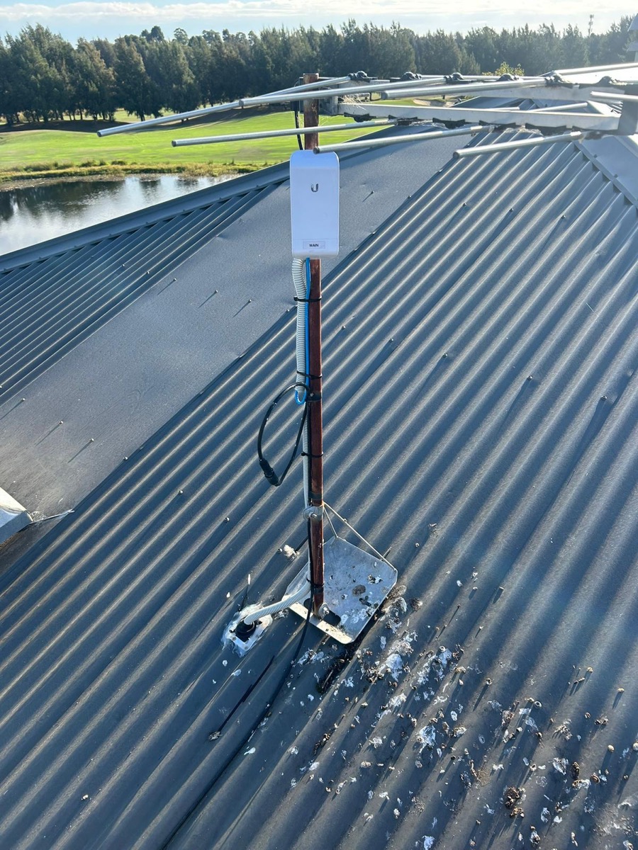 Ubiquiti wireless access point mounted on a rooftop mast