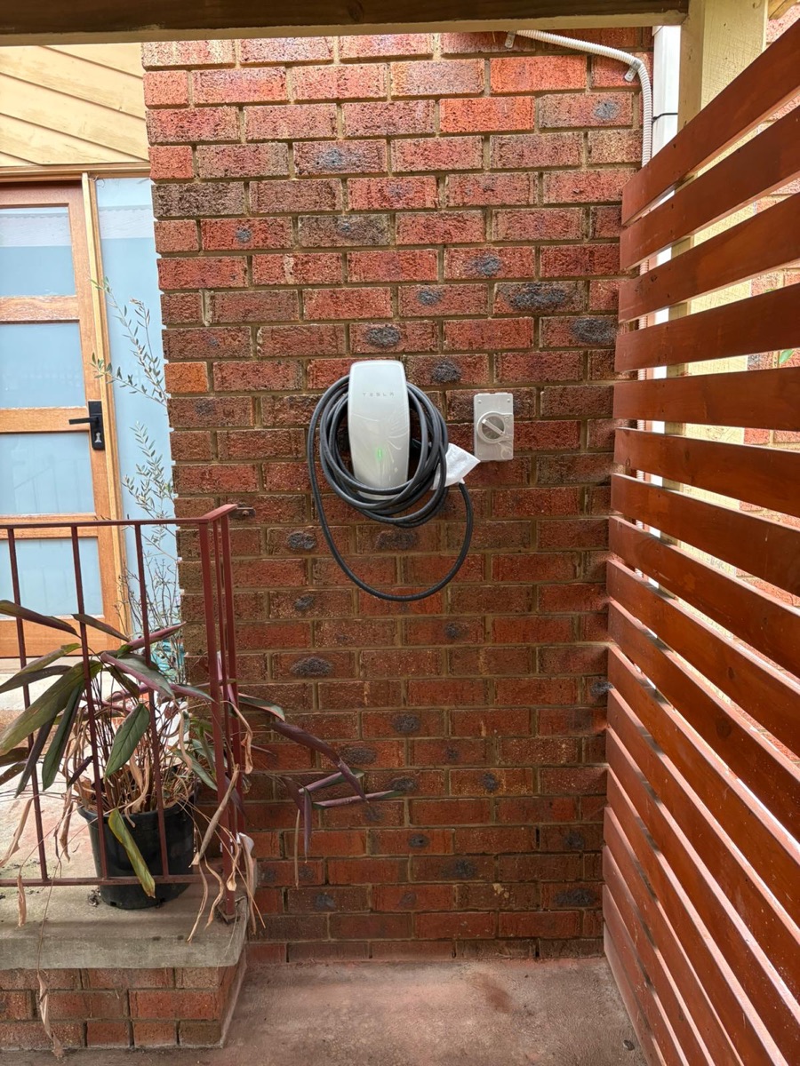 EV charger installed on a brick wall at a home entrance