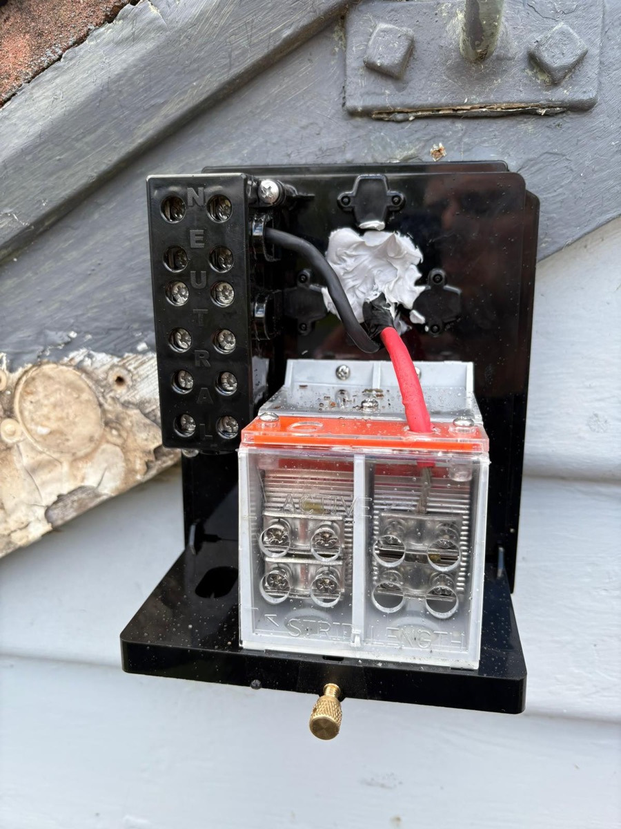 Outdoor electrical connection enclosure on a weatherboard wall