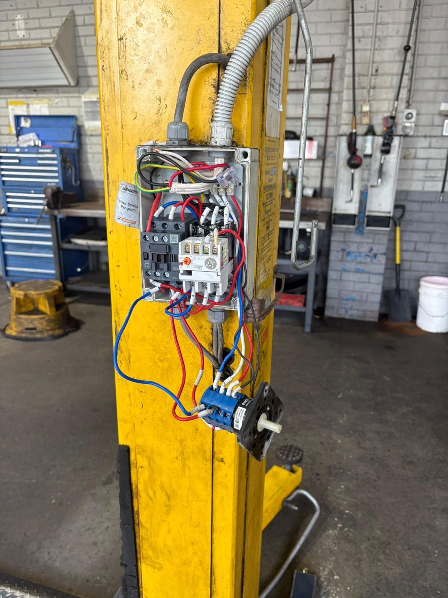 Control wiring exposed on a workshop vehicle hoist during a service