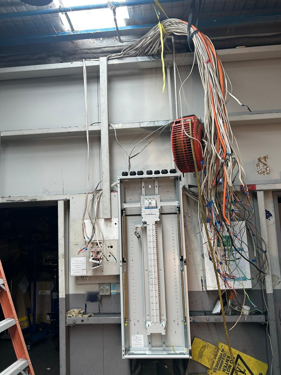 Commercial distribution board mid-install with a large cable loom